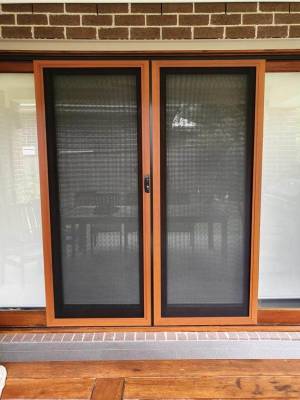 CB: 54 Double Sliding Security Doors Fitted With Stainless Steel Mesh In Cedar Wood Grain Finish & Black Trimmings.