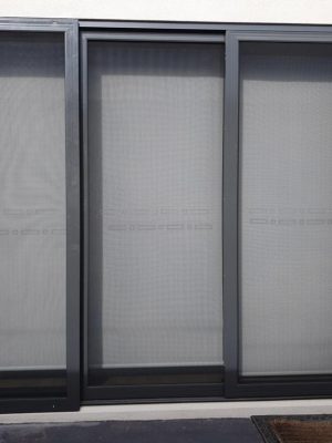 Cb: 56 Stacker Sliding Security Doors Fitted With Stainless Steel Mesh. Displaying The Two Security Doors In A Closed Position &Amp; The Third Security Fixed Panel Fitted With Tamper Proof Screws In Monument.